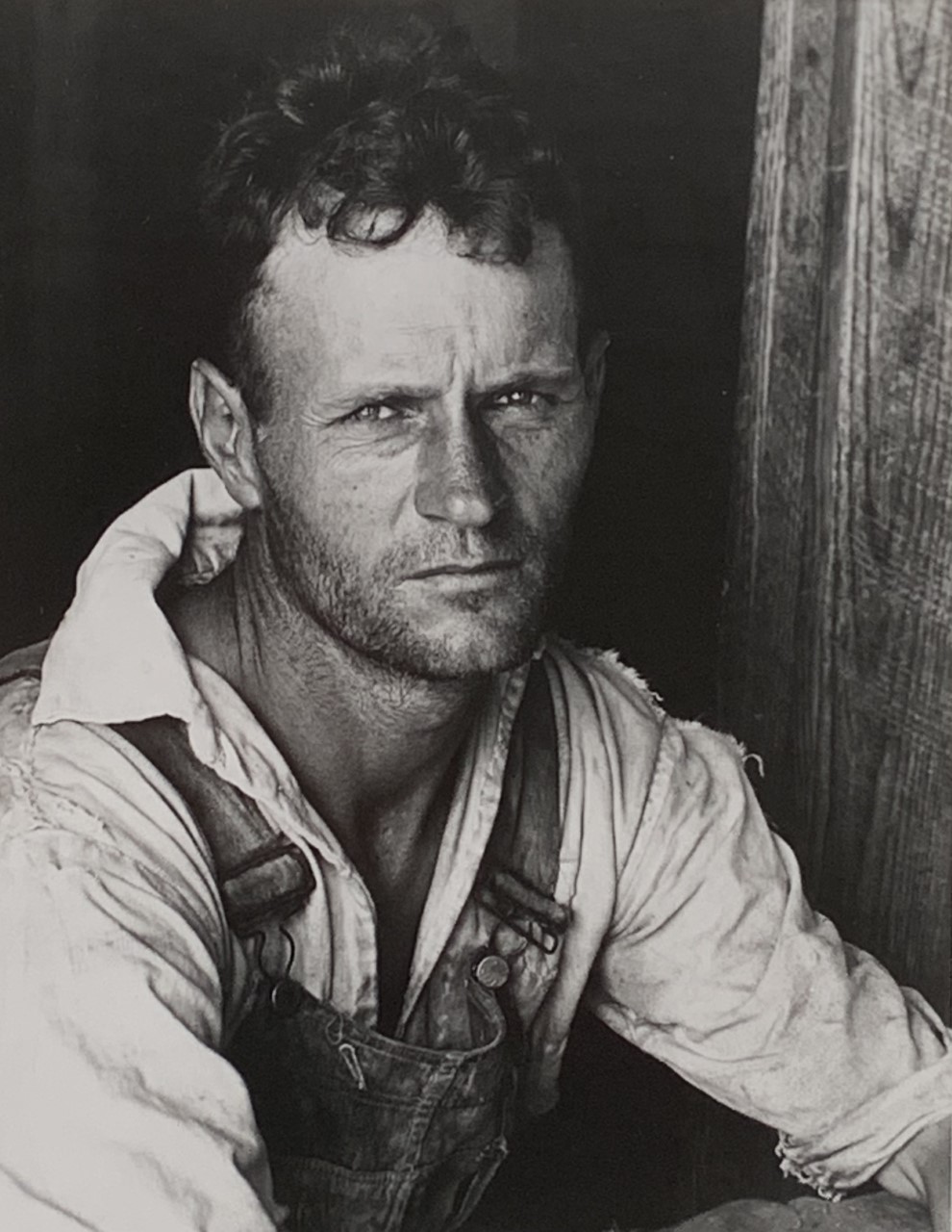 Black and white photograph of a white man in a white shirt and overalls.